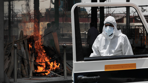 The driver of an ambulance returns after helping cremate the body of a woman who died of COVID-19 on a handcart for cremation in New Delhi, India, Thursday, May 28, 2020.  (AP Photo/Manish Swarup)