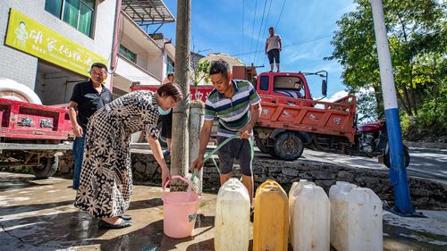 A worker distributes water to residents in Chongqing.