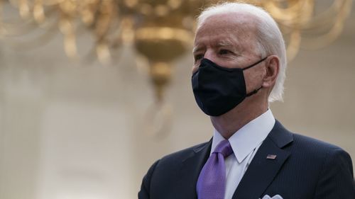 President Joe Biden stands during a performance of the national anthem, during a virtual Presidential Inaugural Prayer Service in the State Dinning Room of the White House, Thursday, Jan. 21, 2021, in Washington