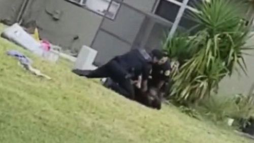 That officer then gets on the ground and restrains the man's upper body, and three other officers surround him as well. (ABC News US)