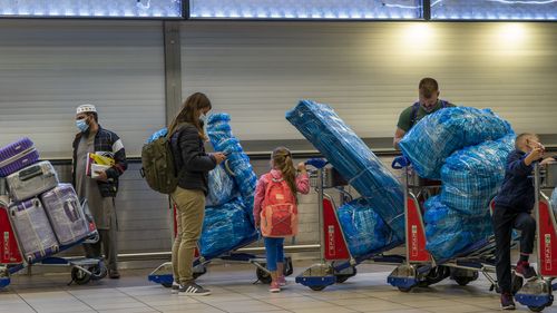 Des gens font la queue pour embarquer sur un vol outre-mer à l'aéroport OR Tambos de Johannesburg, en Afrique du Sud, le vendredi 26 novembre 2021. 