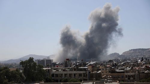 Smoke rises after strikes on Syria's defence ministry in Damascus on July 16.