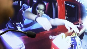 Surveillance video of Philana Holmes reaching for two Happy Meals in the drive-thru at McDonald&#x27;s is shown on a courtroom monitor.
