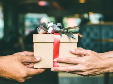 Two people with a Christmas gift in her hands