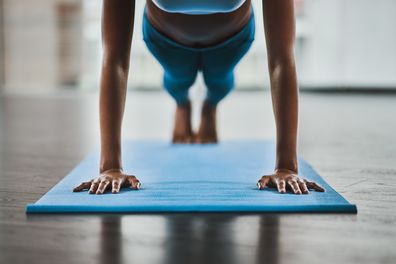 Shot of a woman doing pushups during her workout routine at home.