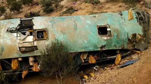 A handout photo made available by Andina shows the wreckage of a passenger bus that overturned and plunged into a ravine in the southern region of Arequipa, Peru. (Via AP)