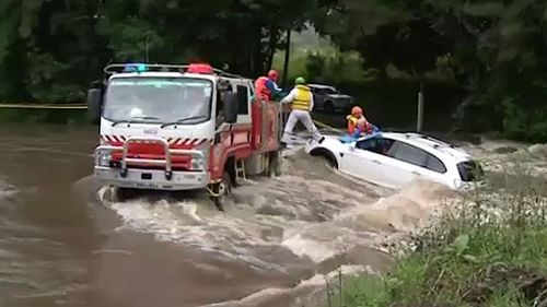 NSW SES and Fire and Rescue crews were called in to tether the car so it would not float further down the rising floodwaters near Taree NSW (Supplied).