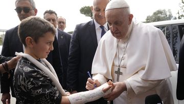 Pope Francis autographs the plaster cast of a child as he leaves the Agostino Gemelli University Hospital in Rome, Saturday, April 1, 2023 after receiving treatment for a bronchitis, The Vatican said.  