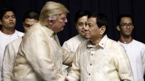 President Donald Trump shakes hand with Philippines President Rodrigo Duterte during the gala dinner. (AAP)