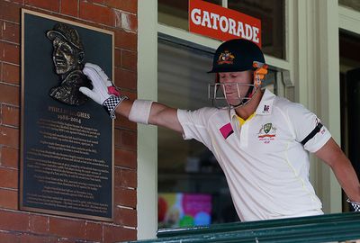Warner touches the Hughes plaque on his way to bat.