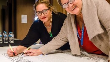 Uluru Dialogue co-chairs Professor Megan Davis and Pat Anderson sign the Uluru Statement from the Heart.