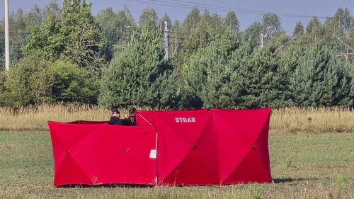 Os bombeiros seguram partes de um UAV danificado abatido pelas autoridades polonesas em um local em Czosnowka, perto de Biala Podlaska, Polônia.
