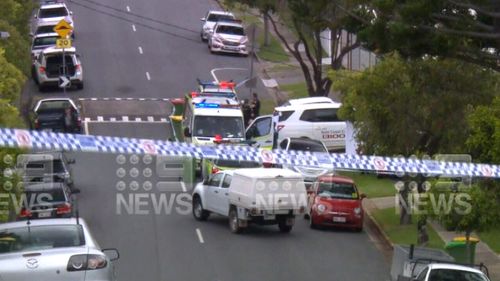 Police vehicles inside a cordoned off crime scene, where a Gold Coast man was found dead