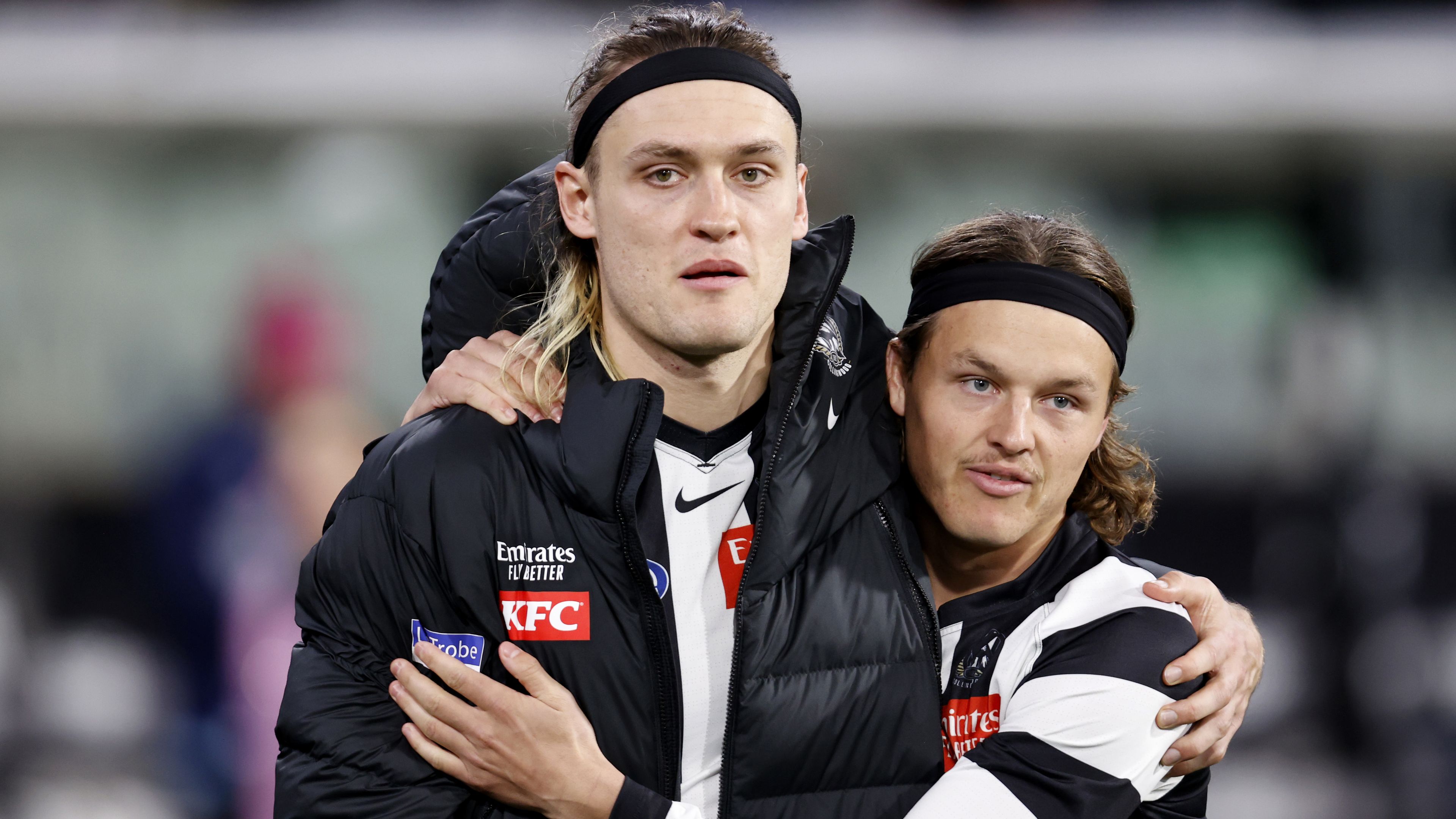 Darcy Moore and Jack Ginnivan embrace after a hamstring injury to the Pies captain.