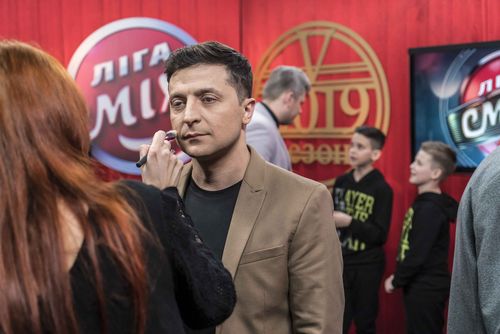 Ukrainian presidential candidate Volodymyr Zelenskiy (C) has makeup applied backstage during the filming of his comedy show Liga Smeha (League of Laughter) on March 19, 2019 in Kiev, Ukraine