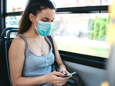 Young woman wearing face mask on public transport.