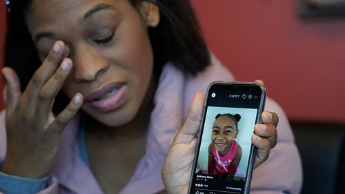 Brittany Tichenor-Cox, holds a photo of her daughter, Isabella "Izzy" Tichenor.