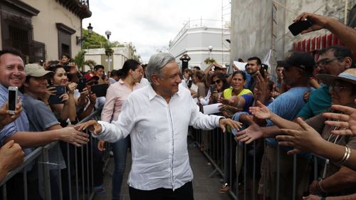 Mexico's President-elect Andres Manuel Lopez Obrador greets supporters in Mazatlan, Mexico, Sunday, Sept. 16, 2018. Lopez Obrador kicked off his nationwide tour with a new security group of 20 people who will rotate five at a time to accompany him everywhere, with the goal of allowing the incoming president to interact with voters. 