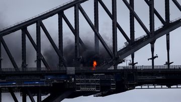 A plume of fire was seen on the Sydney Harbour Bridge on Monday morning after a car burst into flames when it crashed with another vehicle. 