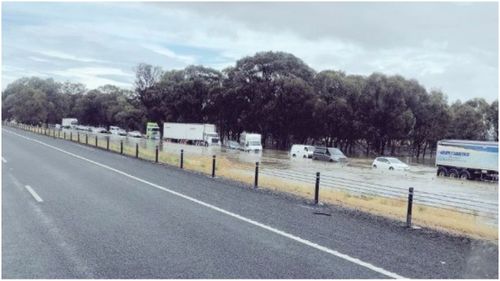 Dozens of cars and trucks trapped in flood water on Victoria's Hume Freeway.