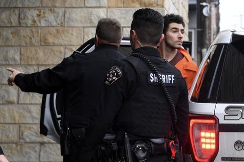 Luigi Nicholas Mangione is escorted into Blair County Courthouse on December 10.