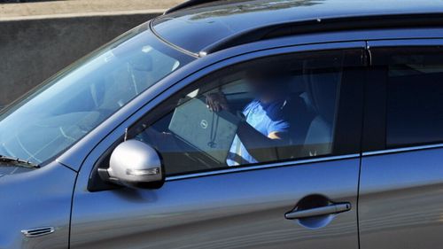 One man was spotted balancing a laptop on his steering wheel. (9NEWS)