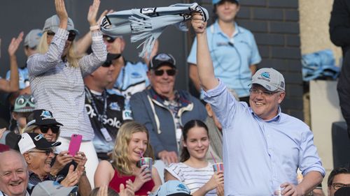 Newly reelected Prime Minister Scott Morrison waves to the crowd during an NRL match between the Cronulla Sharks and the Manly Sea Eagles.