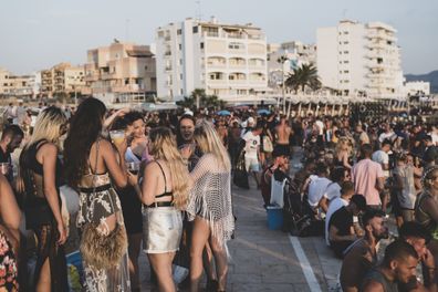 A large crowd of mostly young adults gathers for sunset at the beach on the 'sunset strip' in San Antonio, Ibiza. (August 3, 2018)