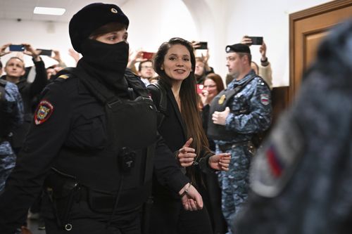 Antonina Favorskaya is escorted by a police officer to the courtroom in the Basmanny District Court in Moscow, Russia, Friday, March 29, 2024. 