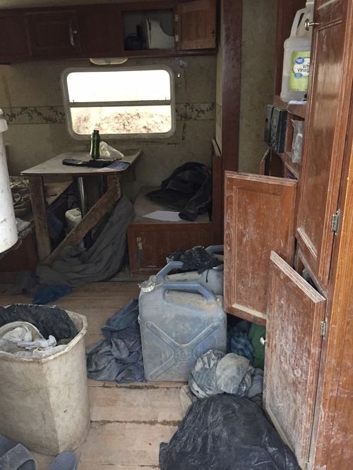 This Friday, Aug. 3, 2018, photo released by Taos County Sheriff's Office shows a rural compound after being found in filthy conditions during an unsuccessful search for a missing 3-year-old boy in Amalia, N.M. Law enforcement officers searching the compound for the missing child didn't locate him but found 11 other children in filthy conditions and hardly any food, a sheriff said Saturday. The children ranging in age from 1 to 15 were removed from the compound and turned over to state child-welfare workers, Taos County Sheriff Jerry Hogrefe said.in Taos, N.M. (Taos County Sheriff's Office via AP)