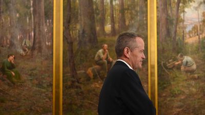 Bill Shorten walks past the painting 'The Pioneer' by Frederick McCubbin.