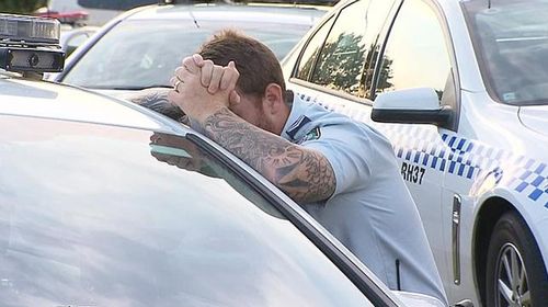 A police officer is overcome with emotion at the scene of the incident. 