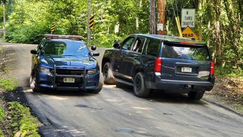 New York State Police block off a road near the scene where the body of Roy Den Hollander was found.