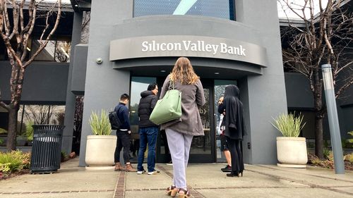 People stand outside of an entrance to Silicon Valley Bank in Santa Clara, Calif., Friday, March 10, 2023. 