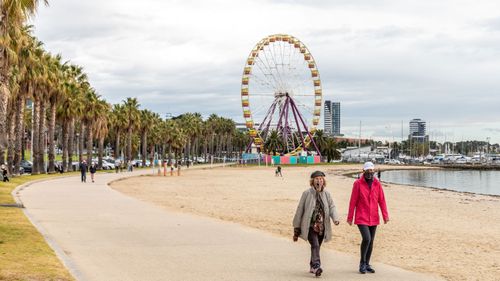 People are seen walking wearing face-masks along the Geelong Waterfront.