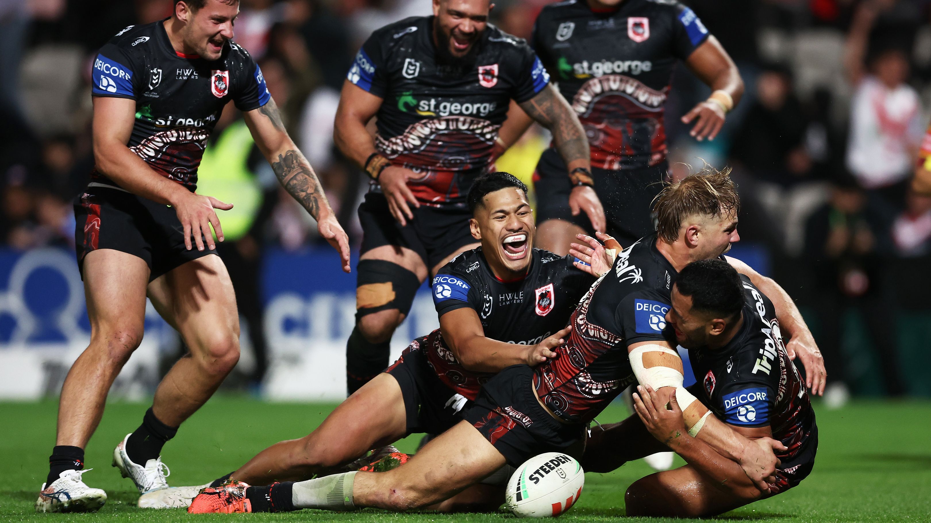 Mathew Feagai celebrates with his Dragons teammates after scoring the match-winning try against the Roosters.