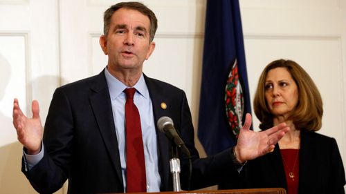 Virginia Governor Ralph Northam, left, with his wife Pam talks to the media in the governor mansion.