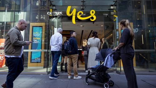 Customers line up outside an Optus shop fron