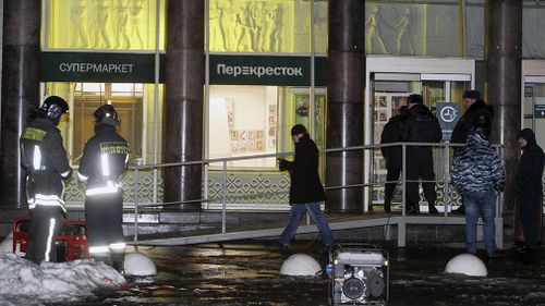 Police stand at the entrance of a supermarket, after an explosion in St.Petersburg, Russia. (AAP)