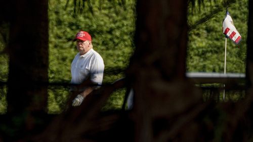 President Donald Trump plays golf at his Trump International Golf Club in West Palm Beach, Florida.