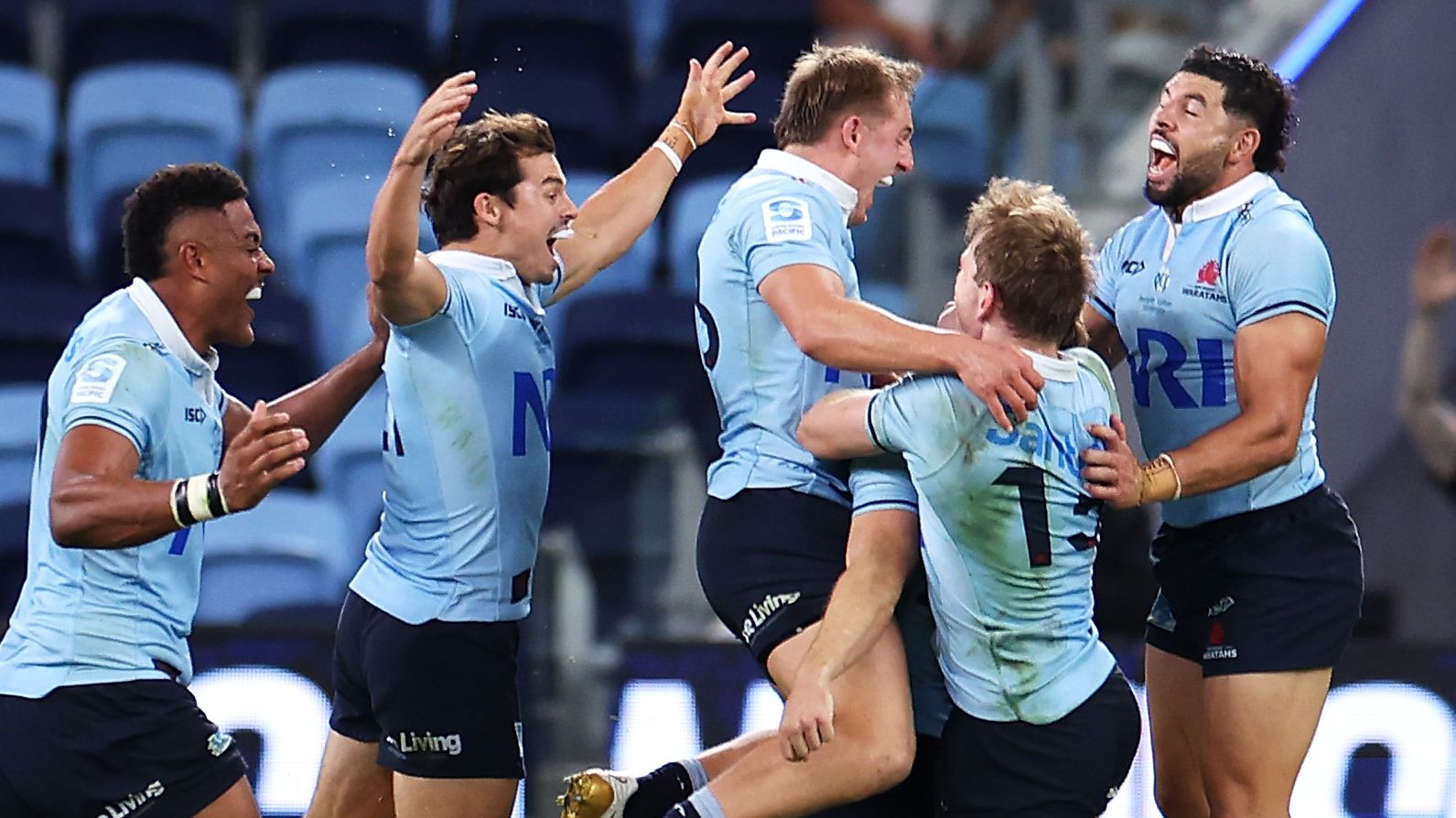 The Waratahs celebrate with Will Harrison of the Waratahs after he kicked the winning field goal in golden point during the round eight Super Rugby Pacific match between NSW Waratahs and Crusaders.