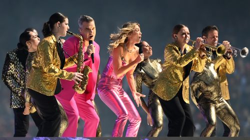 Robbie Williams and Delta Goodrem perform during the 2022 AFL Grand Final match between the Geelong Cats and the Sydney Swans at the Melbourne Cricket Ground on September 24, 2022 in Melbourne, Australia. (Photo by Quinn Rooney/Getty Images)