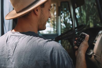 Harry Vick, van life influencer, using an emergency GME communication device / handheld radio