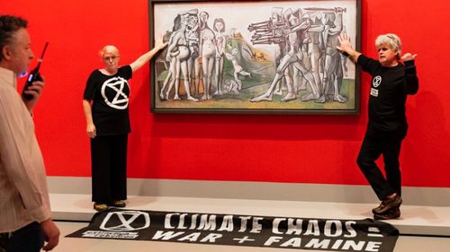Climate change protesters have been arrested after gluing themselves to a Picasso painting at the National Gallery of Victoria in Melbourne.