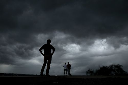 People watch from the Liberty Memorial as a severe storm that dropped several tornados earlier approaches downtown Kansas City, Mo.