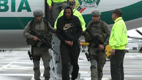 Former Colombian soccer player Jhon Viafara (C) walks scorted by members of Colombian Police upon his arrival to Catam military airport in Bogota, Colombia