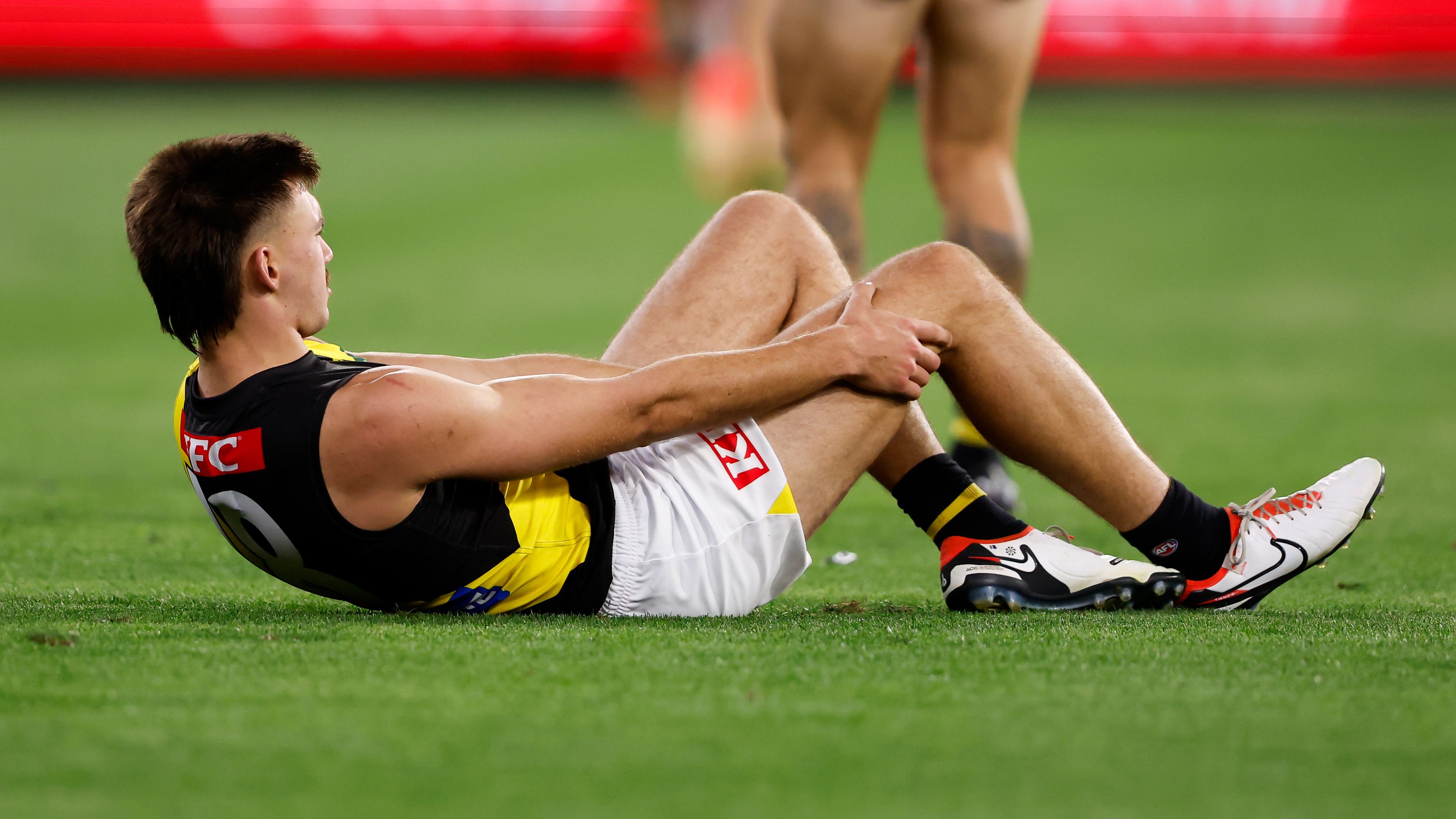 Josh Gibcus of the Tigers is seen with an injured knee during the 2024 AFL Round 01 match between the Carlton Blues and the Richmond Tigers at the Melbourne Cricket Ground on March 14, 2024 in Melbourne, Australia. (Photo by Dylan Burns/AFL Photos via Getty Images)