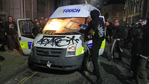 Marchers set fire to a vandalised police van outside Bridewell Police Station.