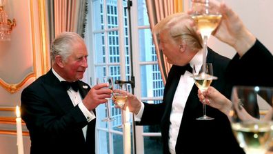 Donald Trump and Prince Charles clinking glasses at an event.