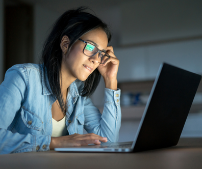 Young girl sits at her computer late at night to study